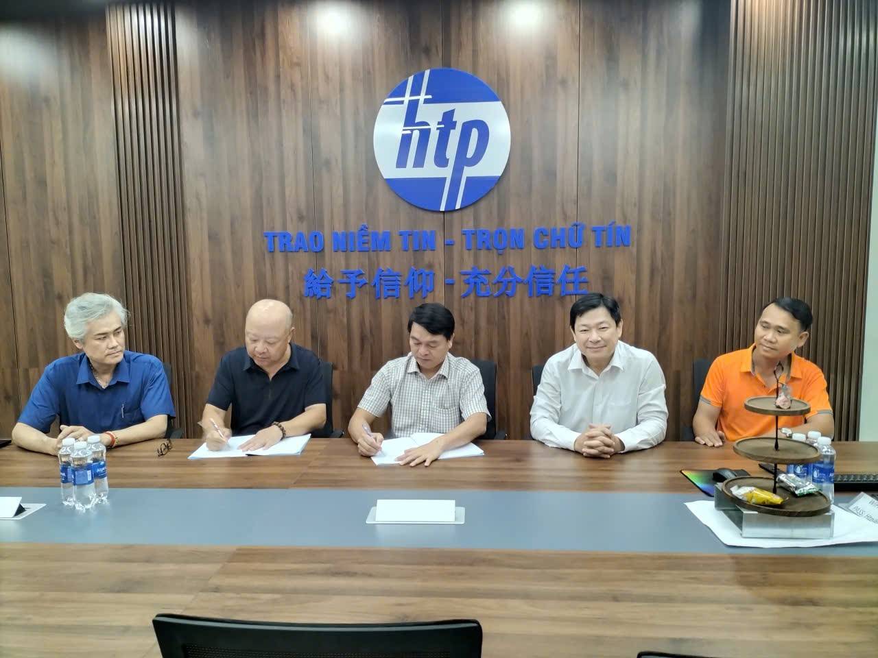 越南環成發建築與陽光市集暨鼎力機電代表在會議桌前簽署合作備忘錄